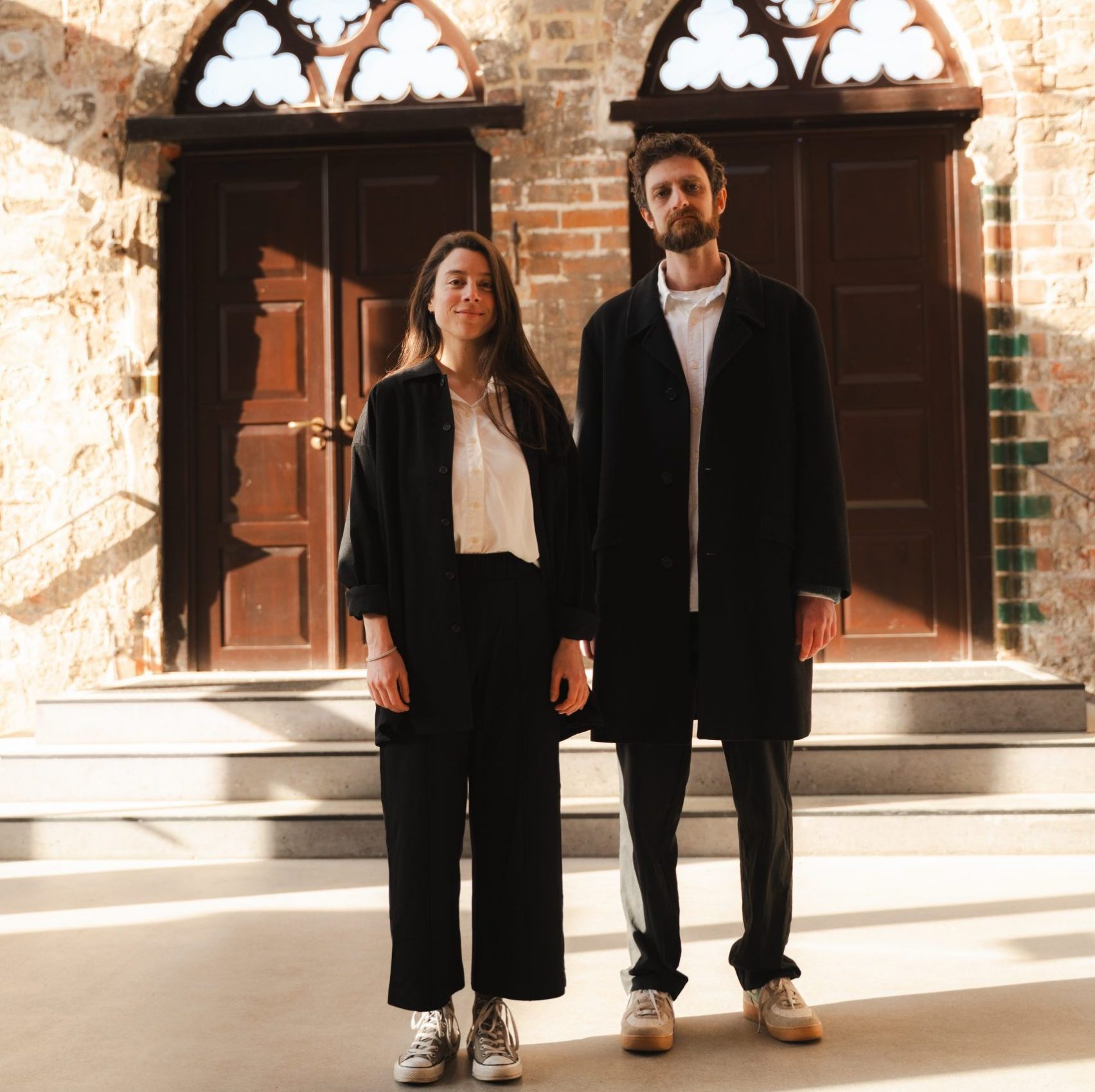 Ein Mann und eine Frau, stilvoll gekleidet vor einem Kircheneingang